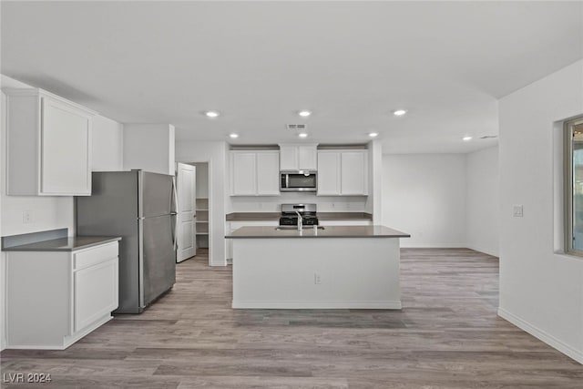 kitchen with white cabinets, sink, appliances with stainless steel finishes, and light hardwood / wood-style floors