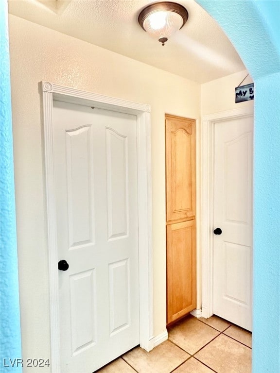 hall featuring light tile patterned flooring