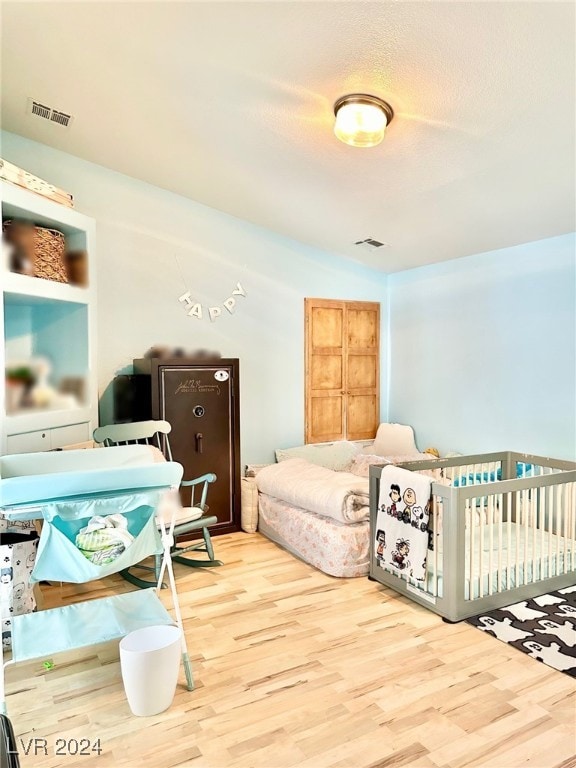 bedroom with a textured ceiling and hardwood / wood-style floors