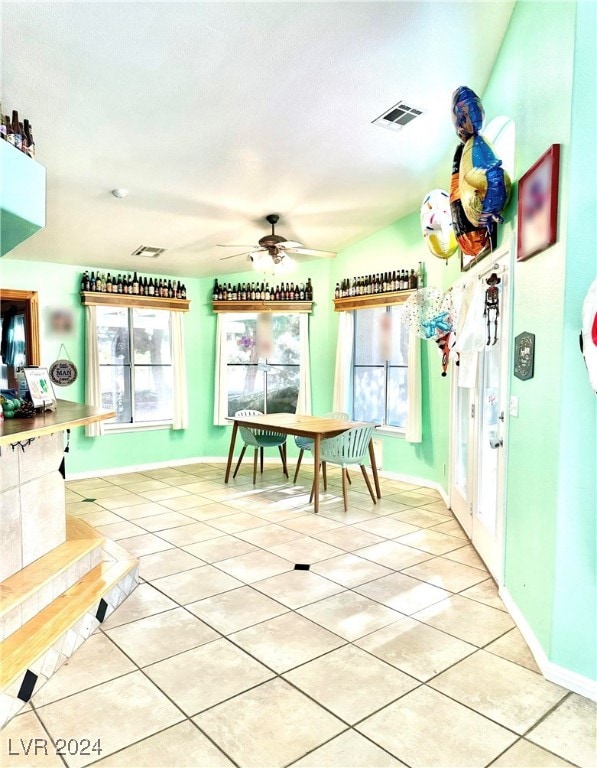 dining space featuring light tile patterned floors, lofted ceiling, and ceiling fan