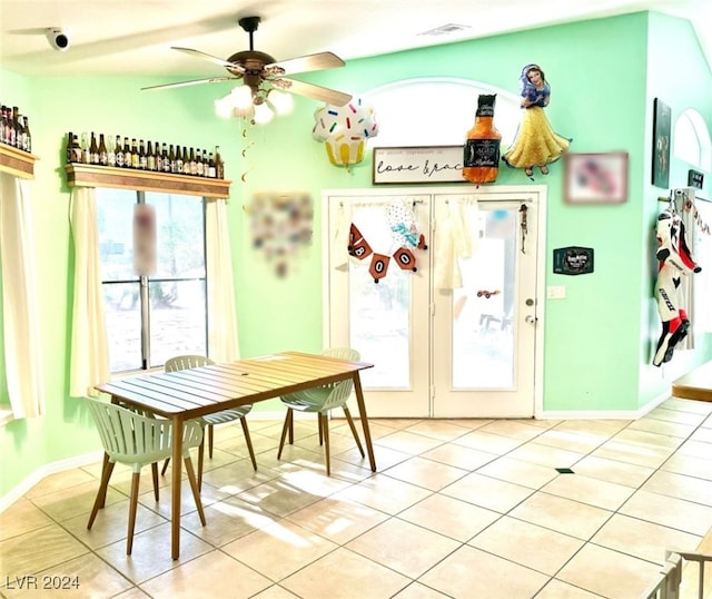 dining space with ceiling fan, vaulted ceiling, and light tile patterned floors