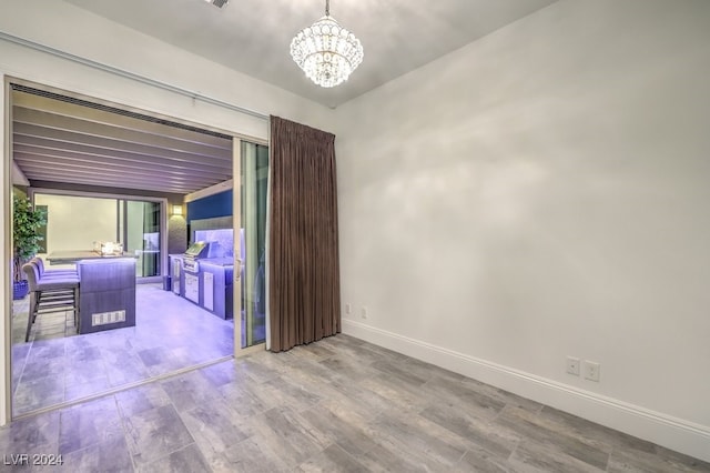 empty room featuring floor to ceiling windows, a chandelier, and hardwood / wood-style floors