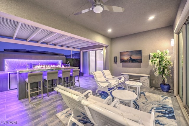 living room with wood-type flooring, ceiling fan, and bar