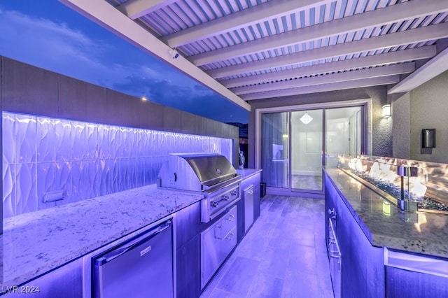 kitchen with stainless steel refrigerator, stone counters, and beam ceiling