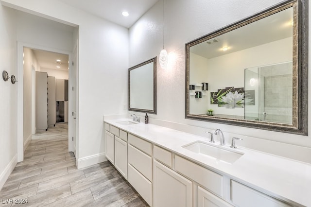 bathroom featuring wood-type flooring, vanity, and a shower with door