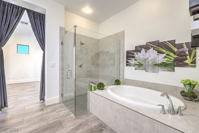 bathroom with shower with separate bathtub and hardwood / wood-style floors