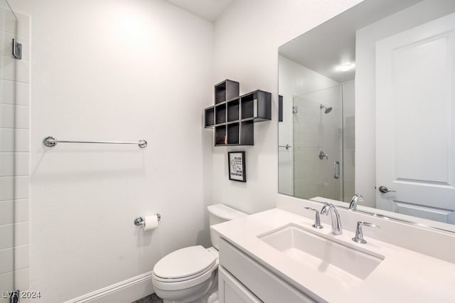 bathroom featuring vanity, toilet, and an enclosed shower