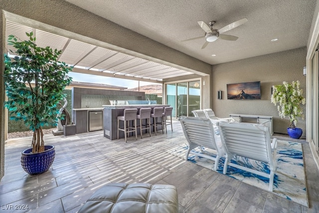 view of patio featuring ceiling fan and exterior kitchen