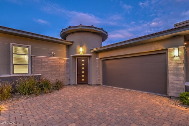 exterior entry at dusk with a garage