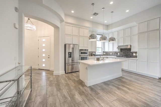 kitchen featuring white cabinetry, pendant lighting, stainless steel appliances, and light hardwood / wood-style flooring