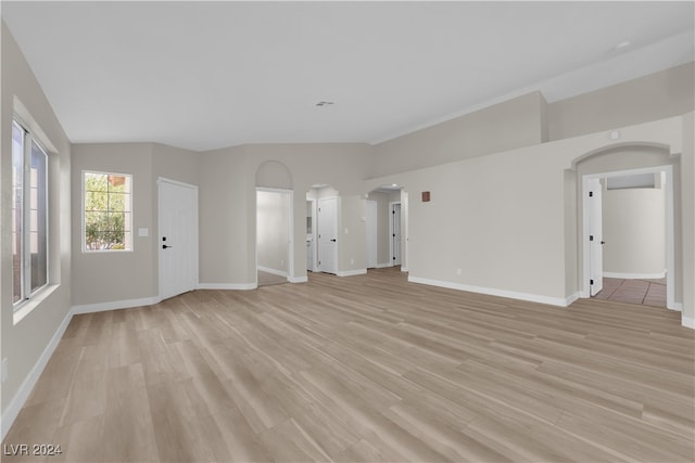 unfurnished living room featuring vaulted ceiling and light wood-type flooring