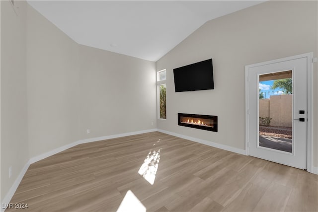 unfurnished living room featuring light hardwood / wood-style floors and lofted ceiling