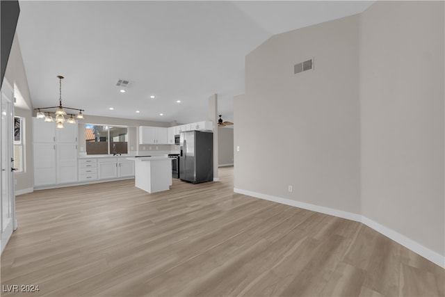 unfurnished living room with light hardwood / wood-style floors, a chandelier, sink, and vaulted ceiling