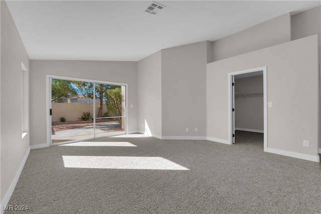 carpeted empty room with lofted ceiling