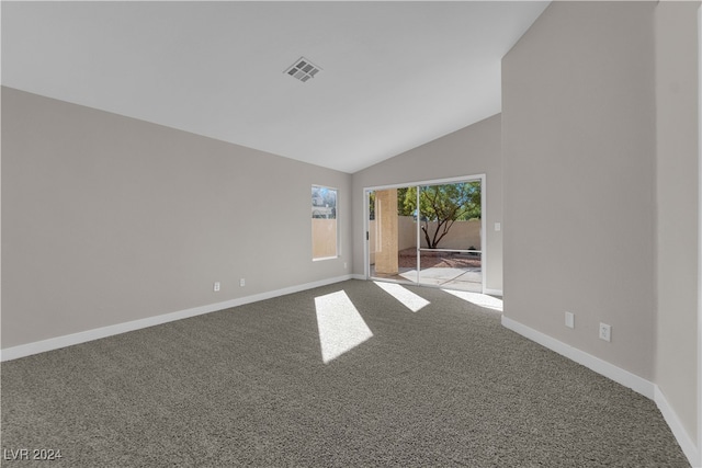 carpeted empty room featuring vaulted ceiling