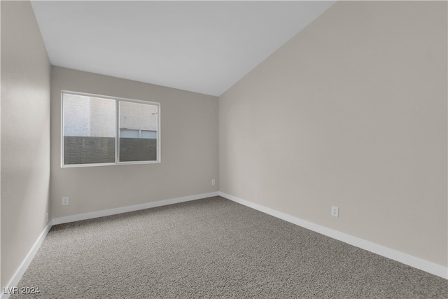 carpeted empty room featuring lofted ceiling