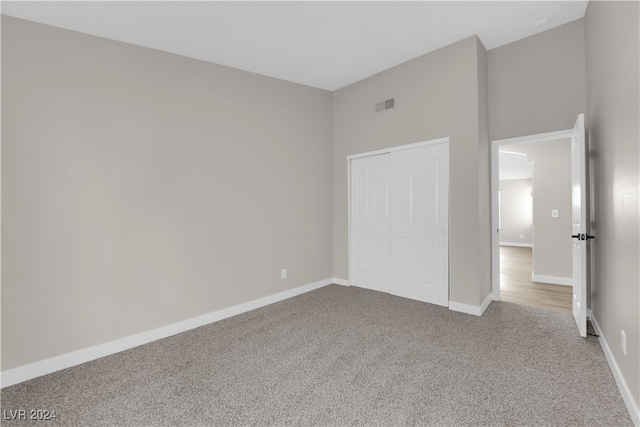 unfurnished bedroom with a closet and light carpet