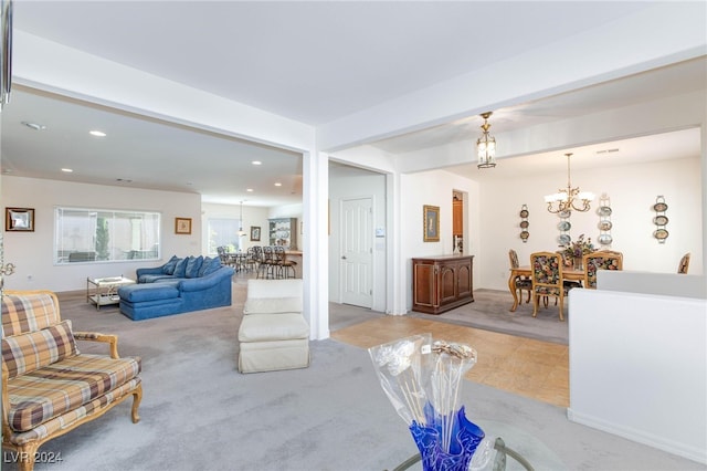 living room featuring light carpet and a notable chandelier