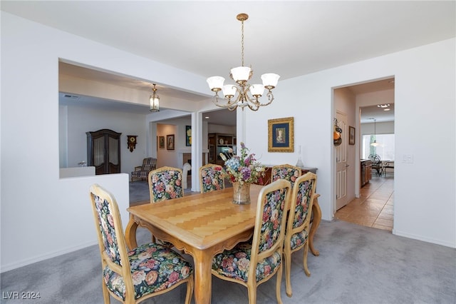 dining space featuring carpet floors and a chandelier