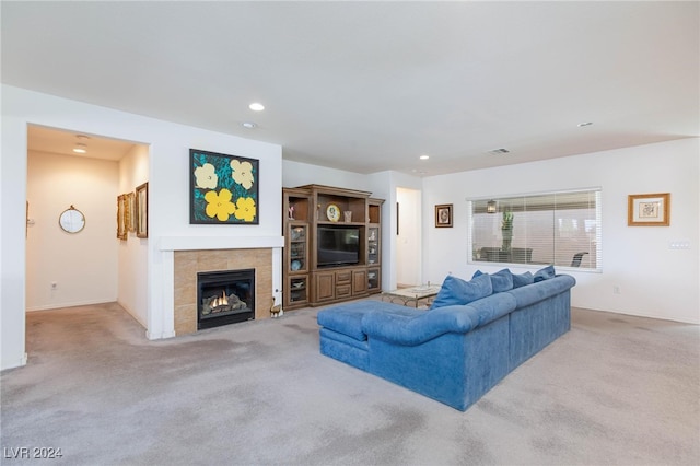 carpeted living room with a tiled fireplace