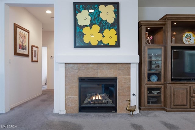 unfurnished living room with a tile fireplace and light colored carpet