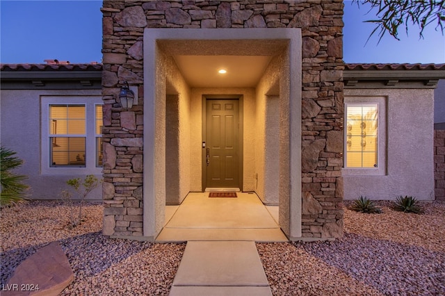 view of exterior entry at dusk