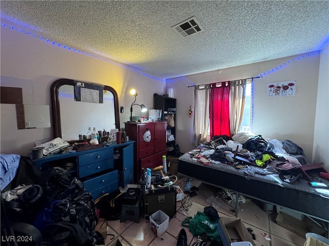 bedroom with tile patterned flooring and a textured ceiling