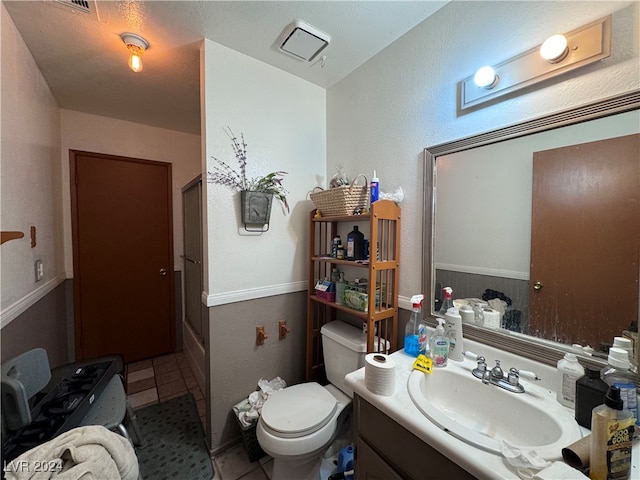 bathroom featuring tile patterned flooring, vanity, and toilet