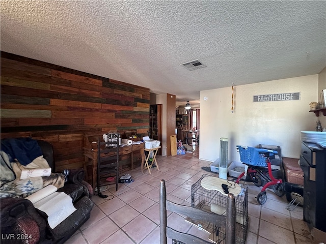 tiled office space featuring wood walls and a textured ceiling