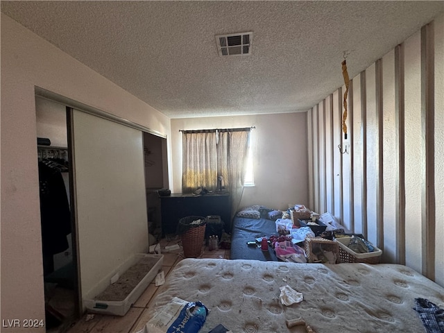 bedroom featuring a textured ceiling and a closet