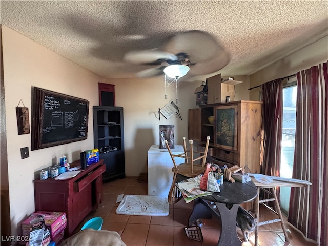 dining space with a textured ceiling, tile patterned flooring, and ceiling fan