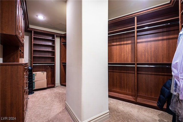 walk in closet featuring light carpet