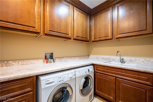 laundry area with sink, washing machine and clothes dryer, and cabinets