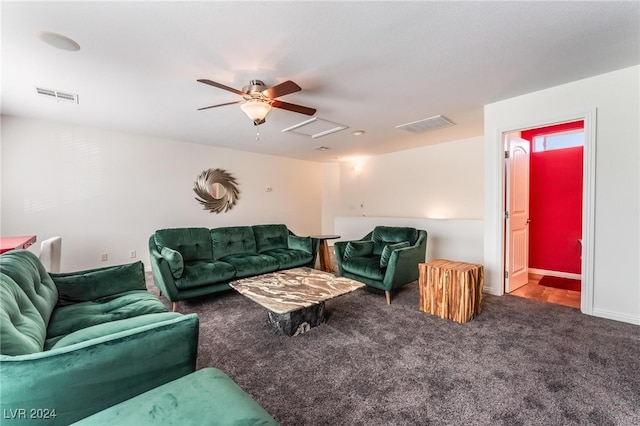 living room featuring dark carpet and ceiling fan