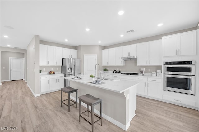 kitchen featuring a kitchen island with sink, sink, white cabinets, and stainless steel appliances