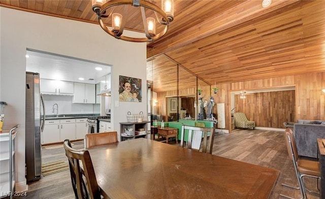 dining room featuring a notable chandelier, wood ceiling, wood walls, wood finished floors, and beamed ceiling