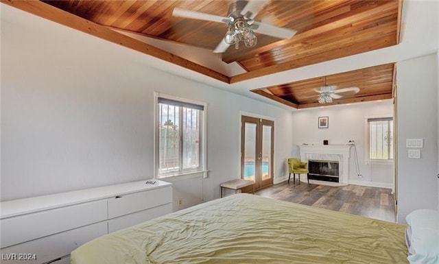 bedroom featuring wooden ceiling, a premium fireplace, wood finished floors, access to outside, and a raised ceiling