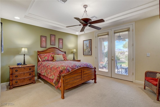 carpeted bedroom with french doors, a tray ceiling, access to exterior, and ceiling fan