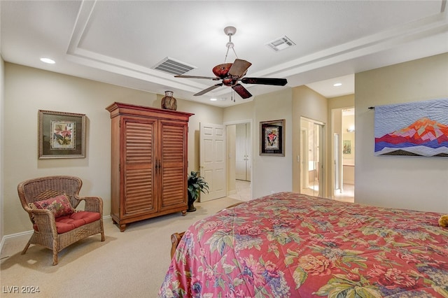 carpeted bedroom with ensuite bath and ceiling fan