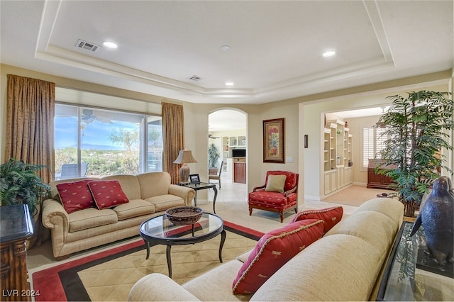 living room featuring a tray ceiling and plenty of natural light