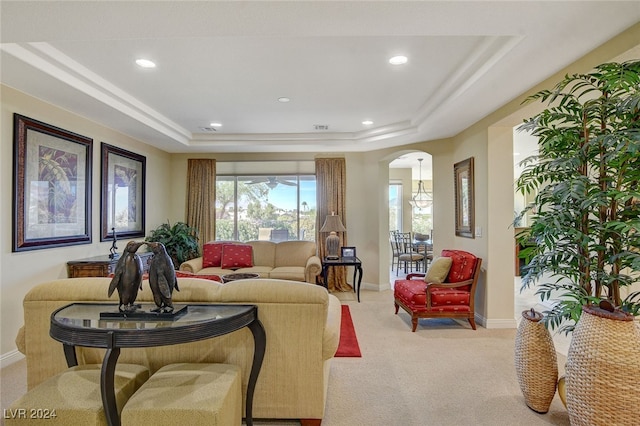 living room featuring light carpet and a raised ceiling