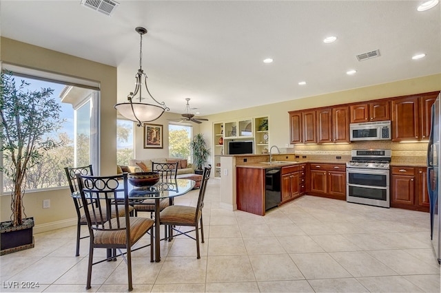 kitchen with stainless steel appliances, light tile patterned floors, plenty of natural light, and decorative light fixtures