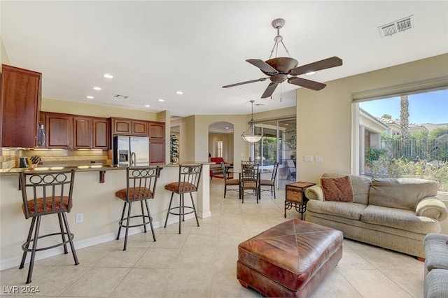 living room with light tile patterned floors, ceiling fan, and a wealth of natural light