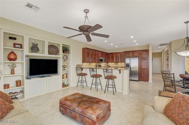 tiled living room with built in shelves and ceiling fan