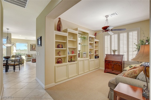 living area featuring light tile patterned flooring and ceiling fan