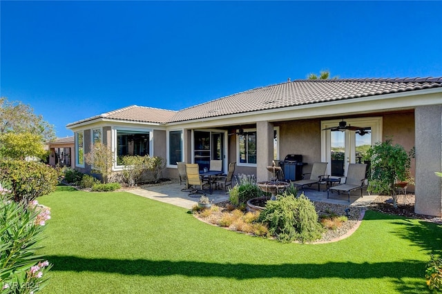 back of house featuring ceiling fan, a lawn, and a patio