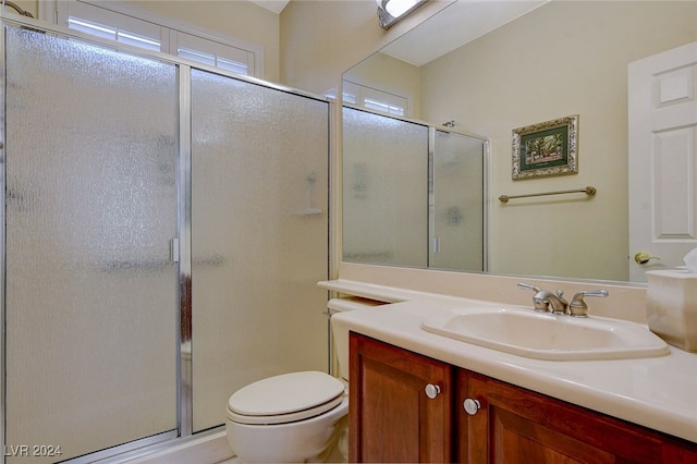 bathroom featuring vanity, toilet, and an enclosed shower