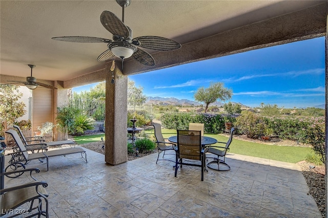 view of patio / terrace with ceiling fan and a mountain view