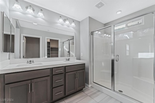 bathroom with tile patterned floors, vanity, and an enclosed shower