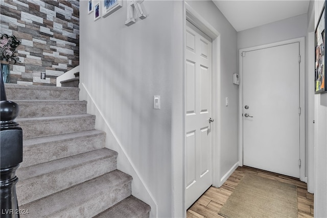 entryway featuring light wood-type flooring and tile walls